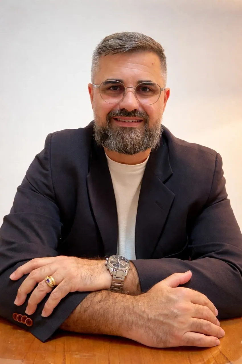 Retrato de Antônio Júnior, psicanalista clínico, sentado à mesa de seu consultório